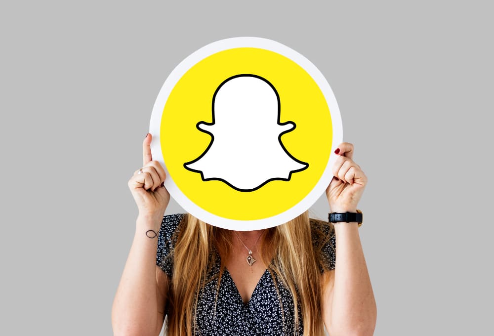 une femme tenant le logo Snapchat